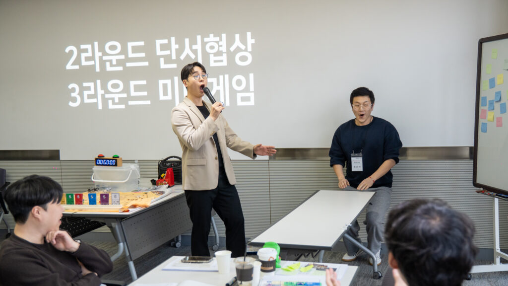 2라운드 단서 획득을 위한 미니게임을 진행하며 분위기를 이끌고 있는 메모리 이벤트 팀빌딩 전문가와 몰입하는 참가자