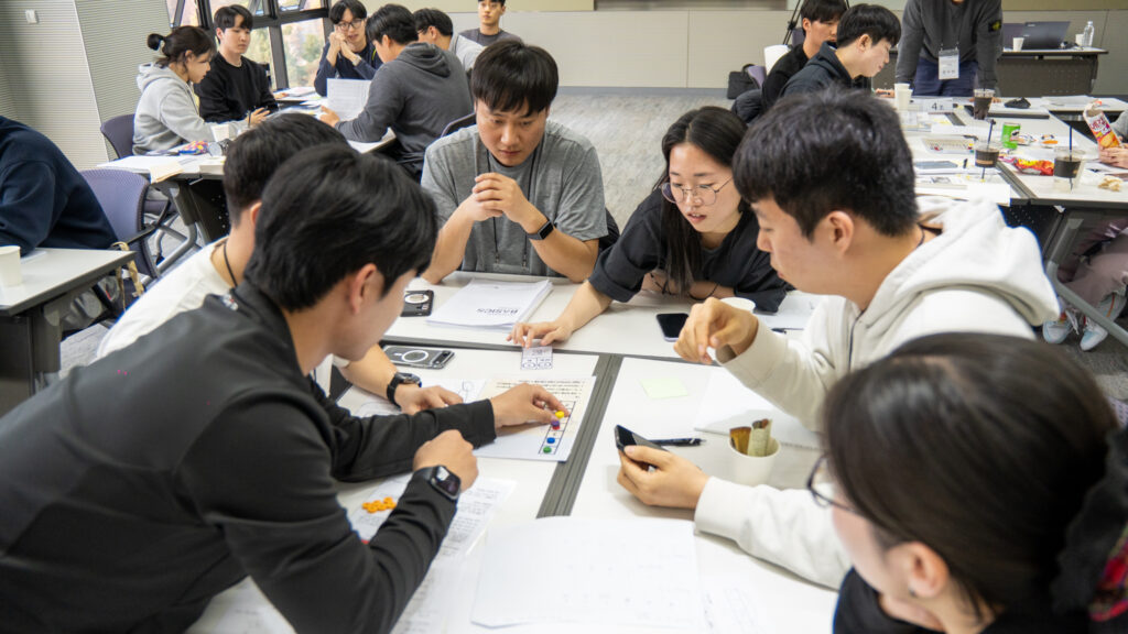 기업 교육 워크샵에서 승리라는 공동 목표를 달성하기 위해 테이블에 모여 앉아 집중력 있게 문제 해결을 논의하는 엔지니어 직원들