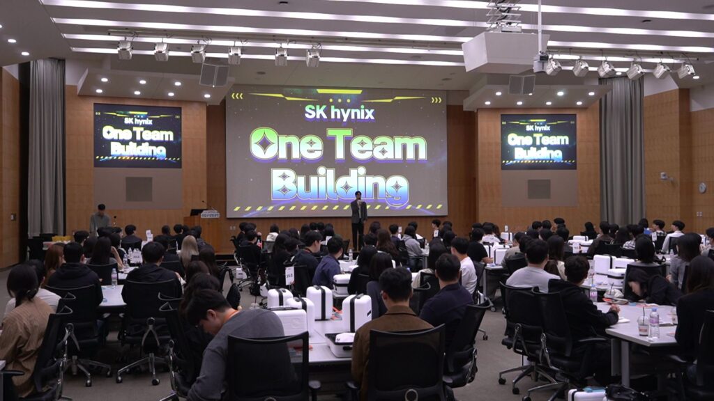 SK하이닉스 One Team Building 타이틀이 띄워진 대형 스크린과 강연장 전체를 가득 채운 열정적인 기업 워크샵 전경