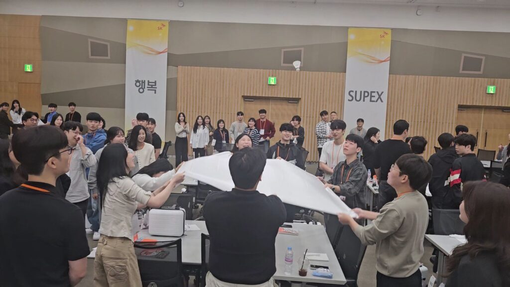 도전 99초 릴레이 미션 중 하나인 보자기 배드민턴에 다 함께 몰입하여 셔틀콕을 튕기는 기업 팀빌딩 화합의 모습